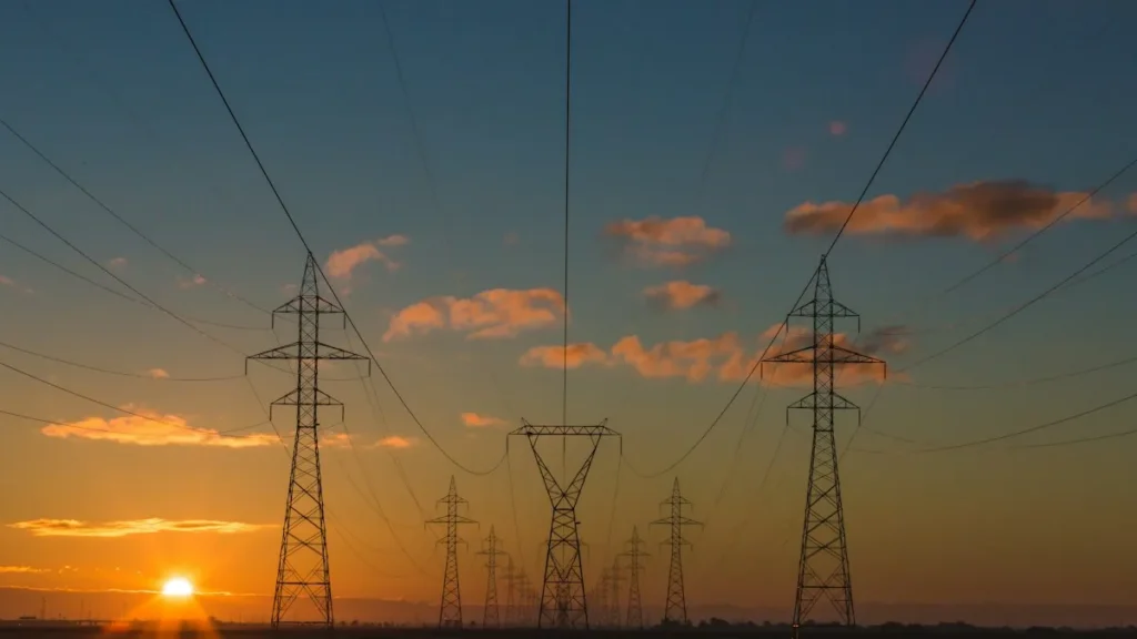 Rede de distribuição de energia elétrica ao entardecer representando desconto na fatura de luz