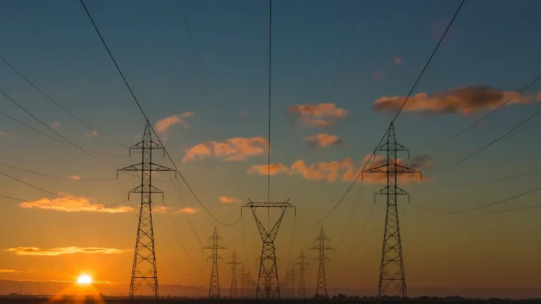 Rede de distribuição de energia elétrica ao entardecer representando desconto na fatura de luz