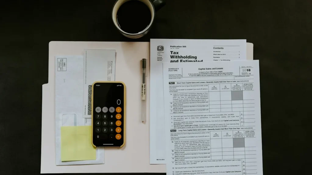 Planilha de apuração tributária, óculos e calculadora para simulação de Imposto de Renda