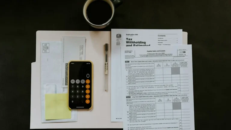 Planilha de apuração tributária, óculos e calculadora para simulação de Imposto de Renda